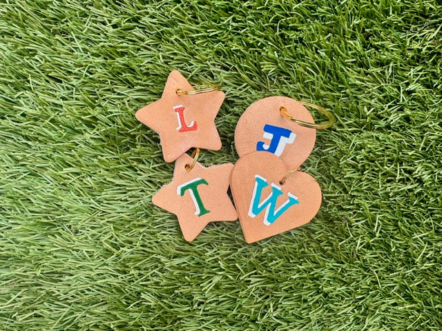 Decorative keychains with letters on a grassy background